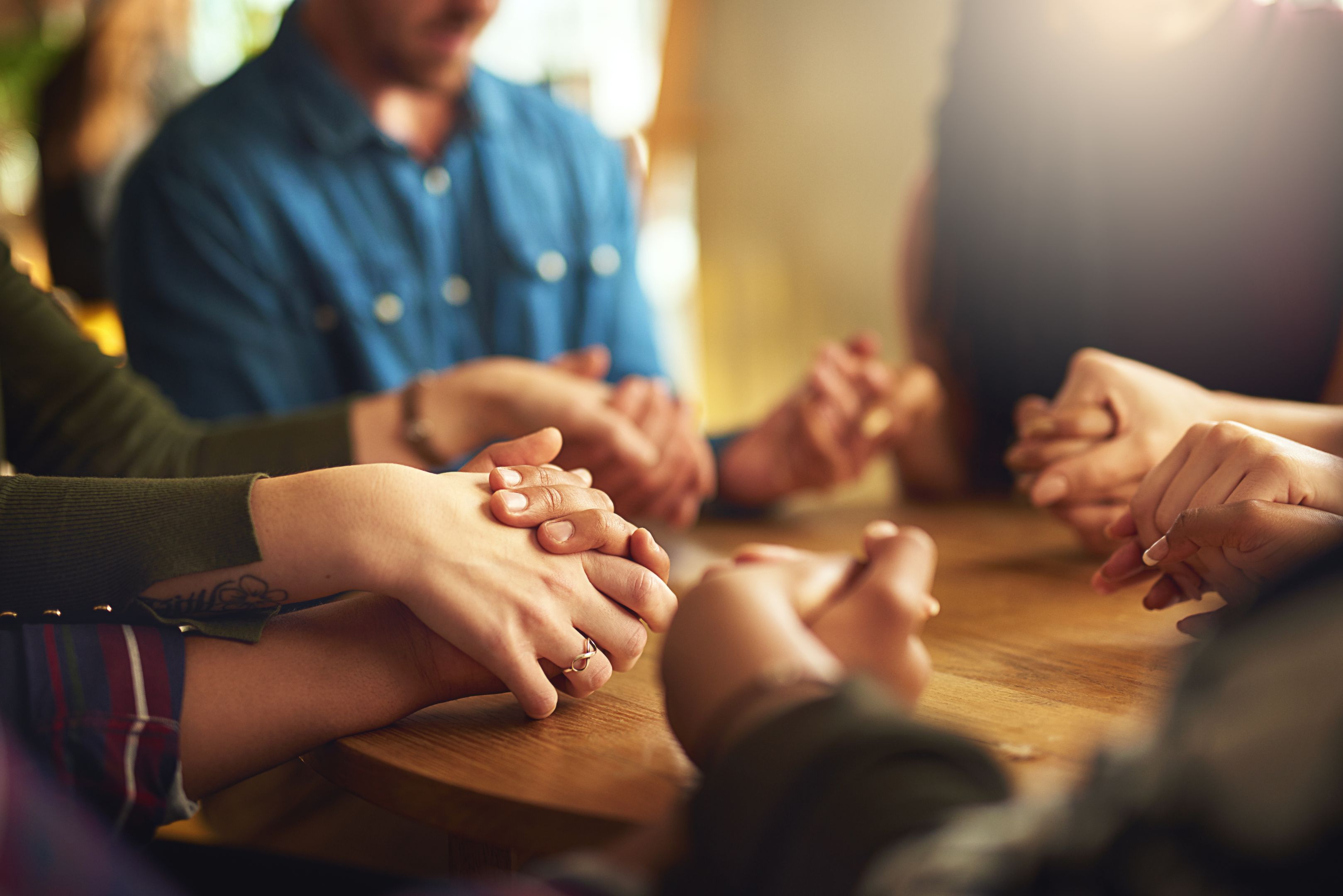 Group of people holding hands and praying together 他们有着强烈的信仰
