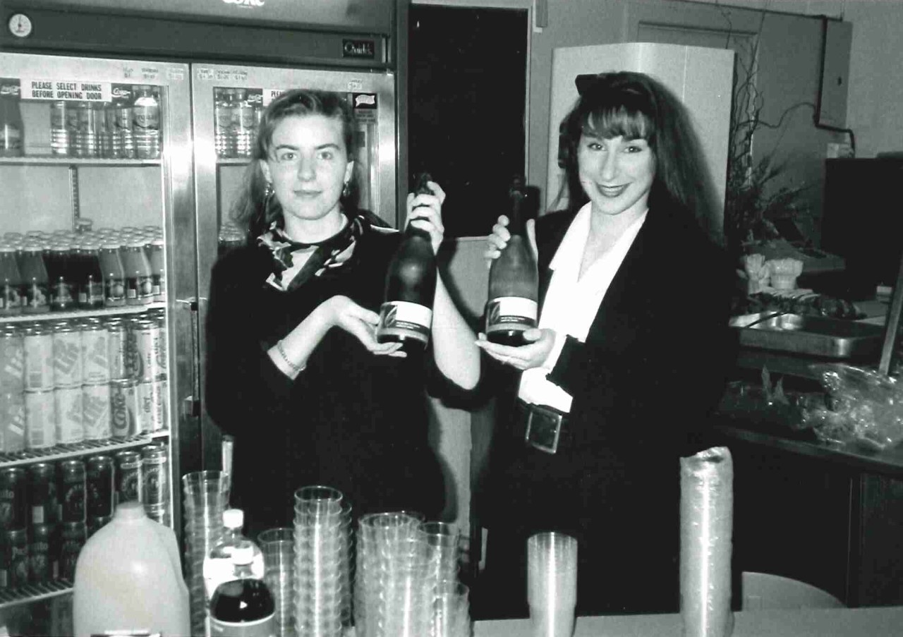 两个女人在酒吧里拿着香槟酒瓶