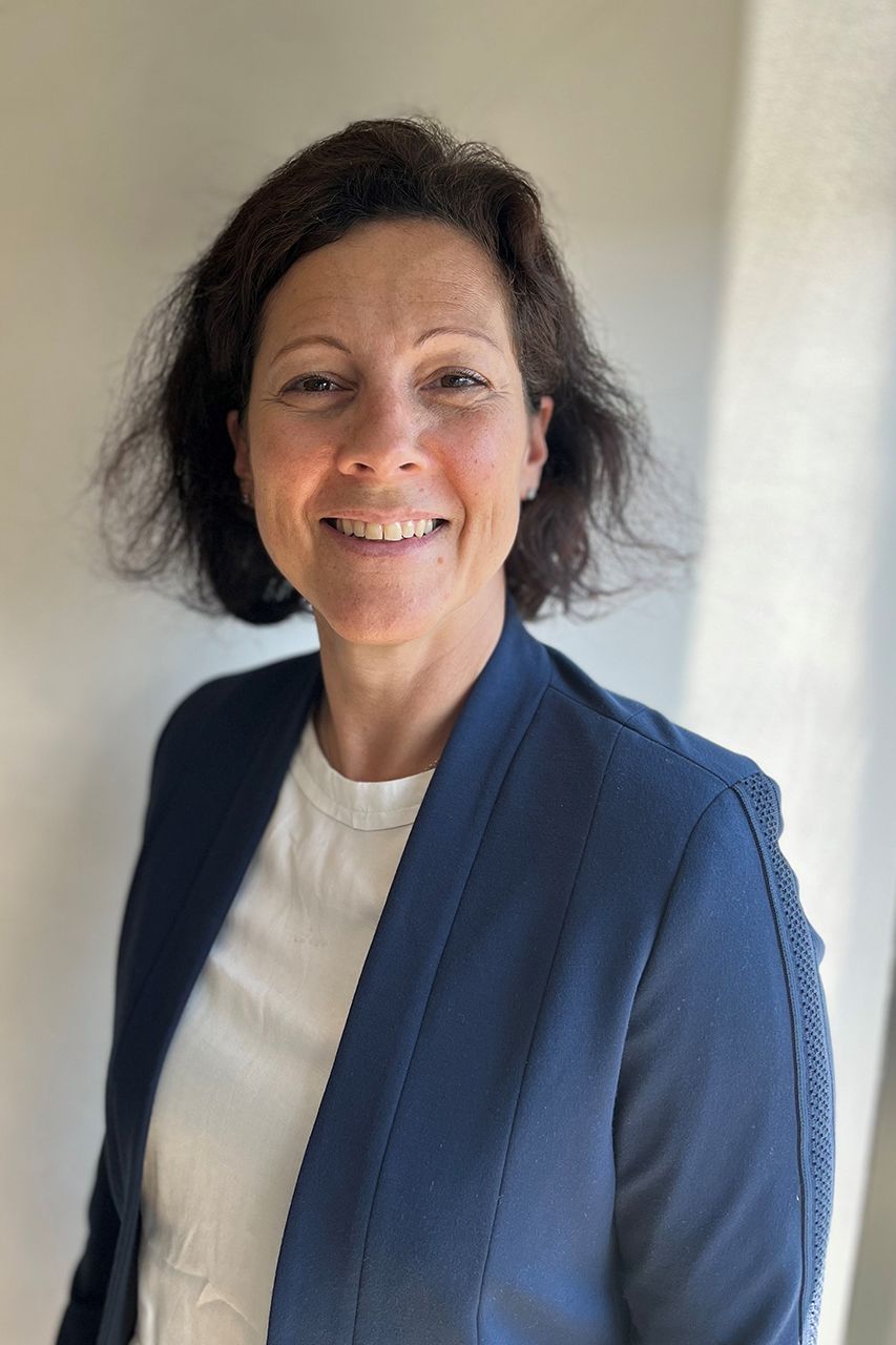 Charlotte Petitprez 夏洛特有一头棕色的短发,穿着一件蓝色的运动上衣。
