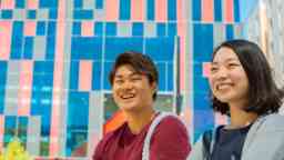两名学生,一男一女,坐在一起笑得很开心