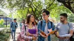 年轻的大学生在校园里走在户外,参与交谈。