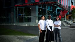 三个学生戴着斯文本科技大学校园品牌服装站在一起——裁剪