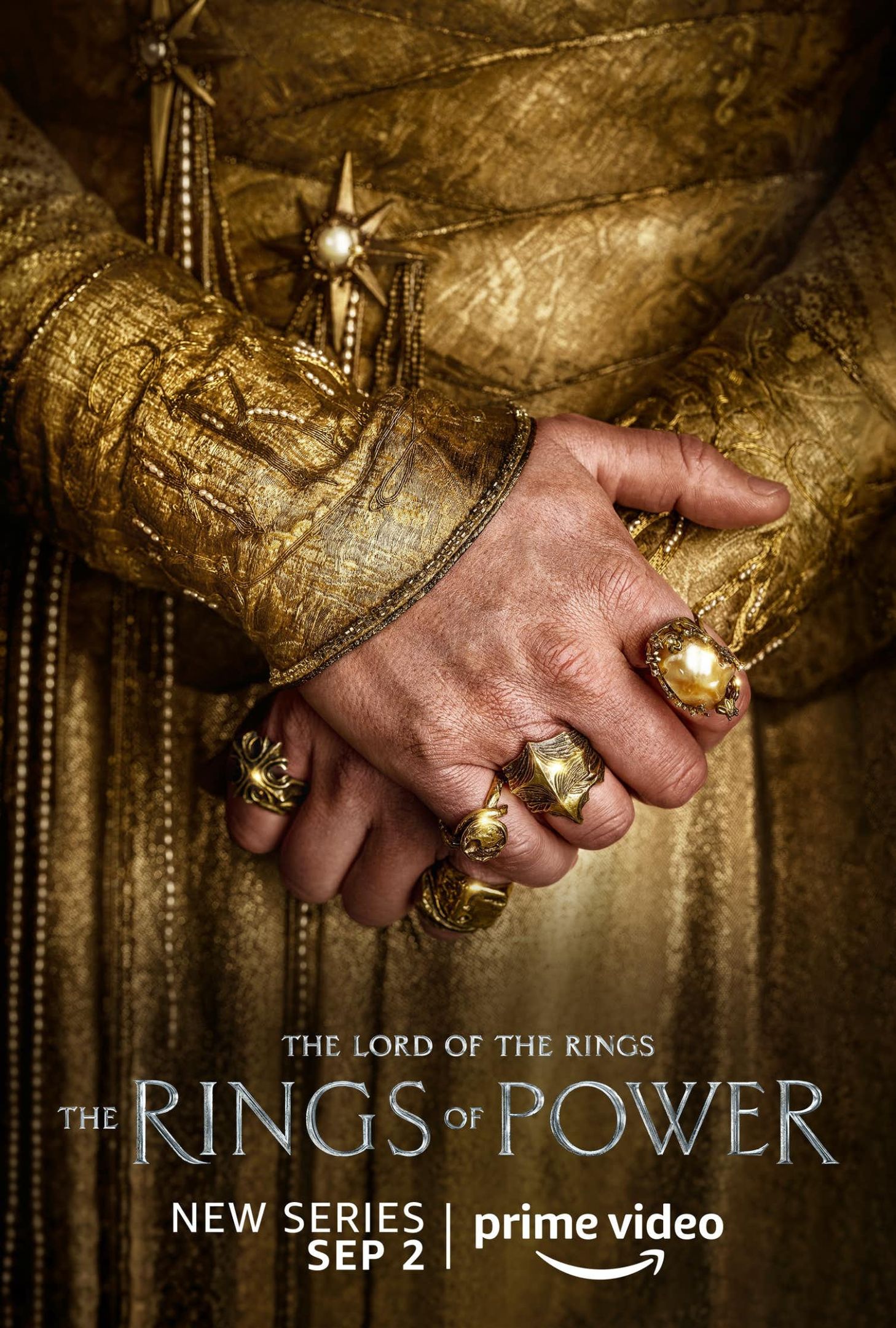 亚马逊的海报工作室即将到来的权力的戒指。有人穿着黄金折叠手手上的戒指可见