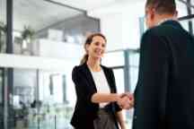 一个女商人和一个商人在一个现代化的办公室里握手