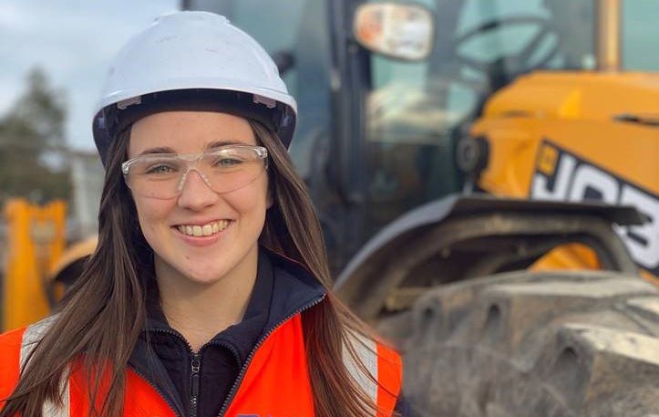 Decmil专业实习学生Kelsey Ingham戴着安全帽和安全背心在建筑工地的照片。