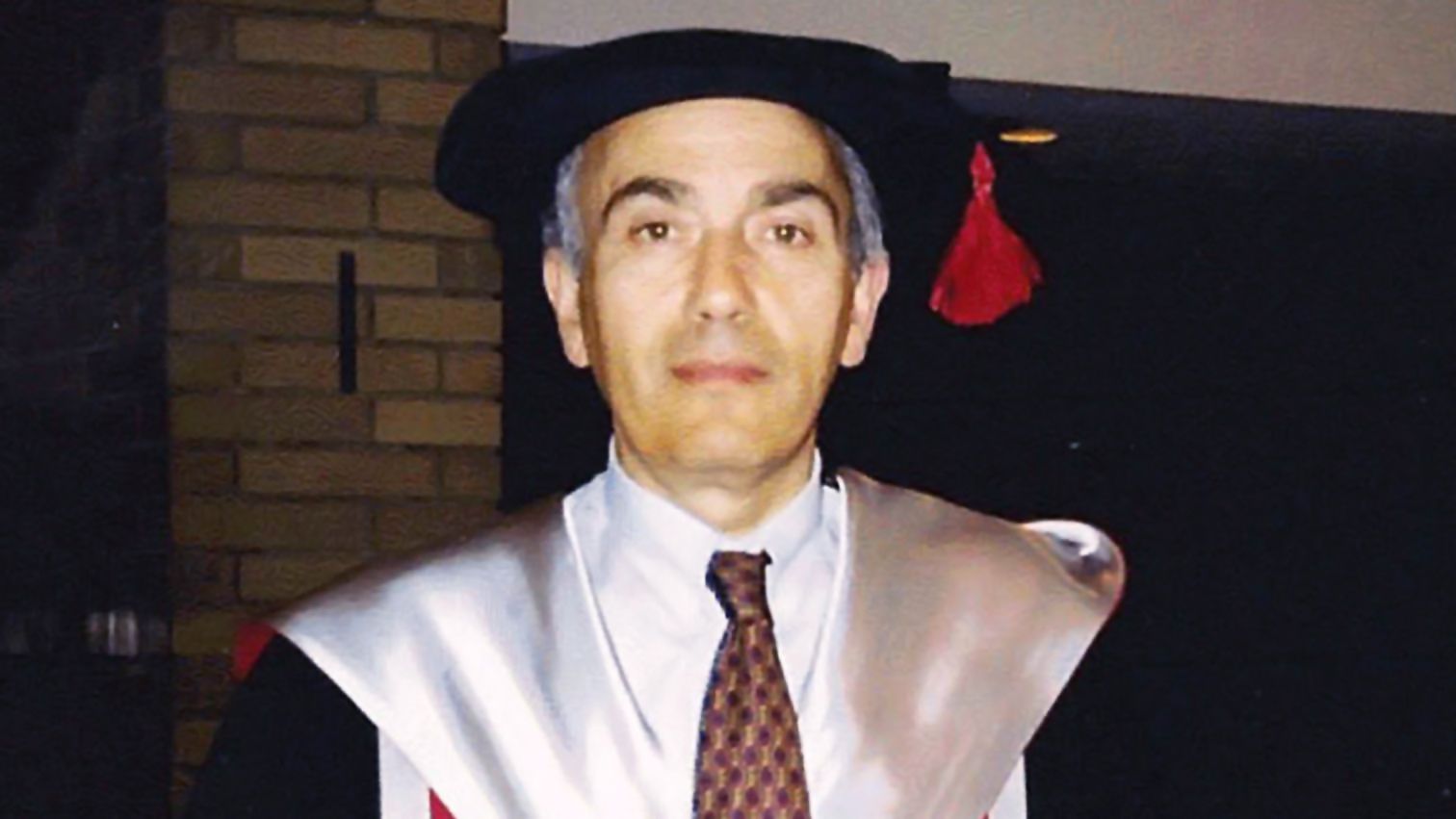 一个男人穿毕业帽和礼服。