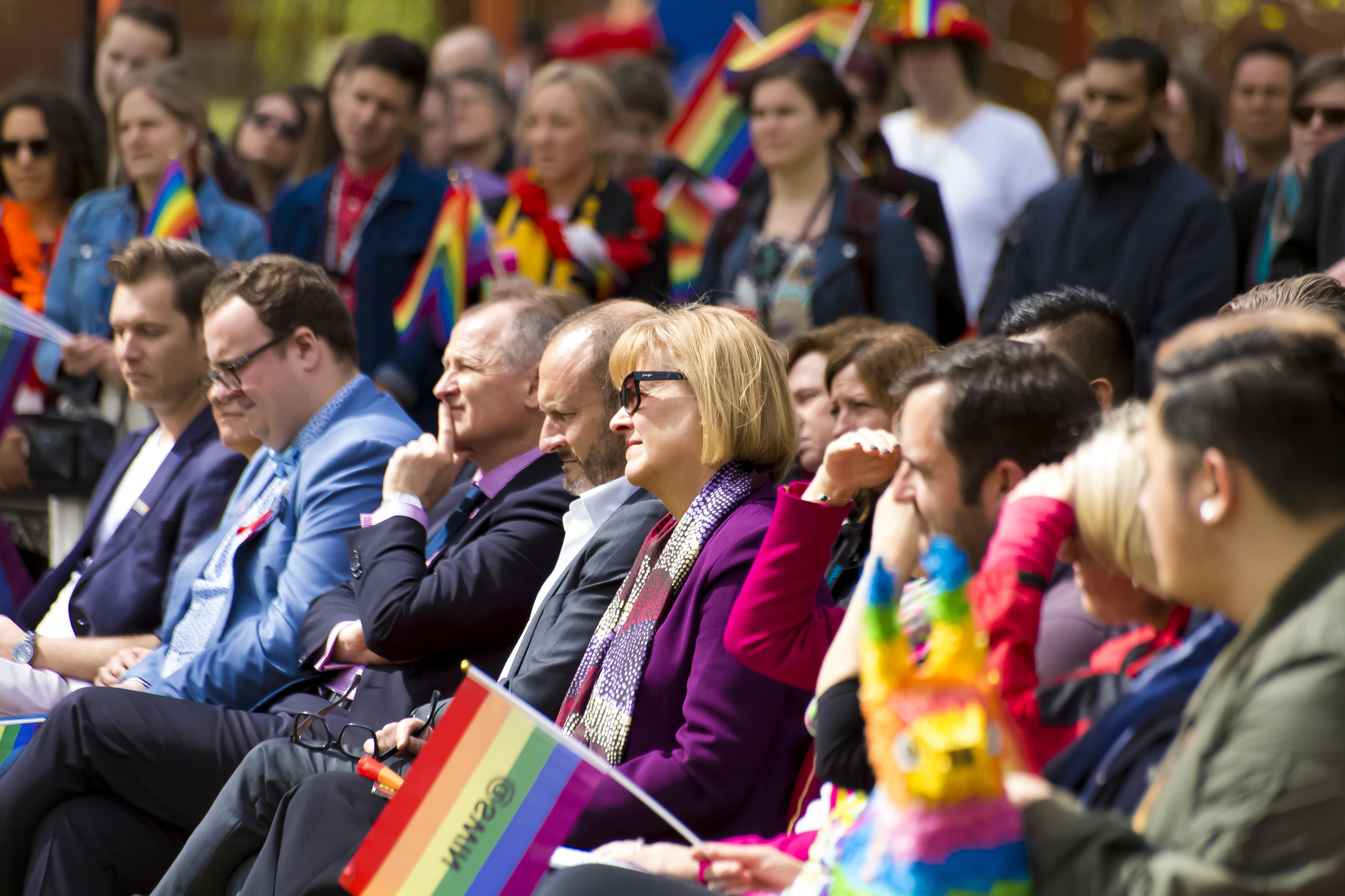 一群人举着彩虹旗参加在校园举行的骄傲日活动