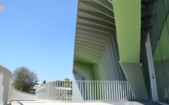 一座现代淡绿色建筑的入口被阳光遮蔽