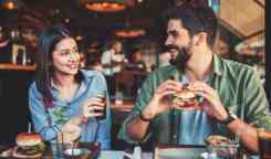 美丽的年轻夫妇坐在咖啡厅,吃早餐。爱,约会、食物、生活方式的概念