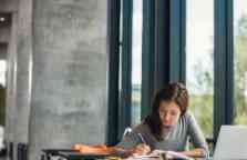 年轻女学生在图书馆学习。