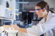 生物学学生穿着实验服，戴着安全眼镜在实验室工作