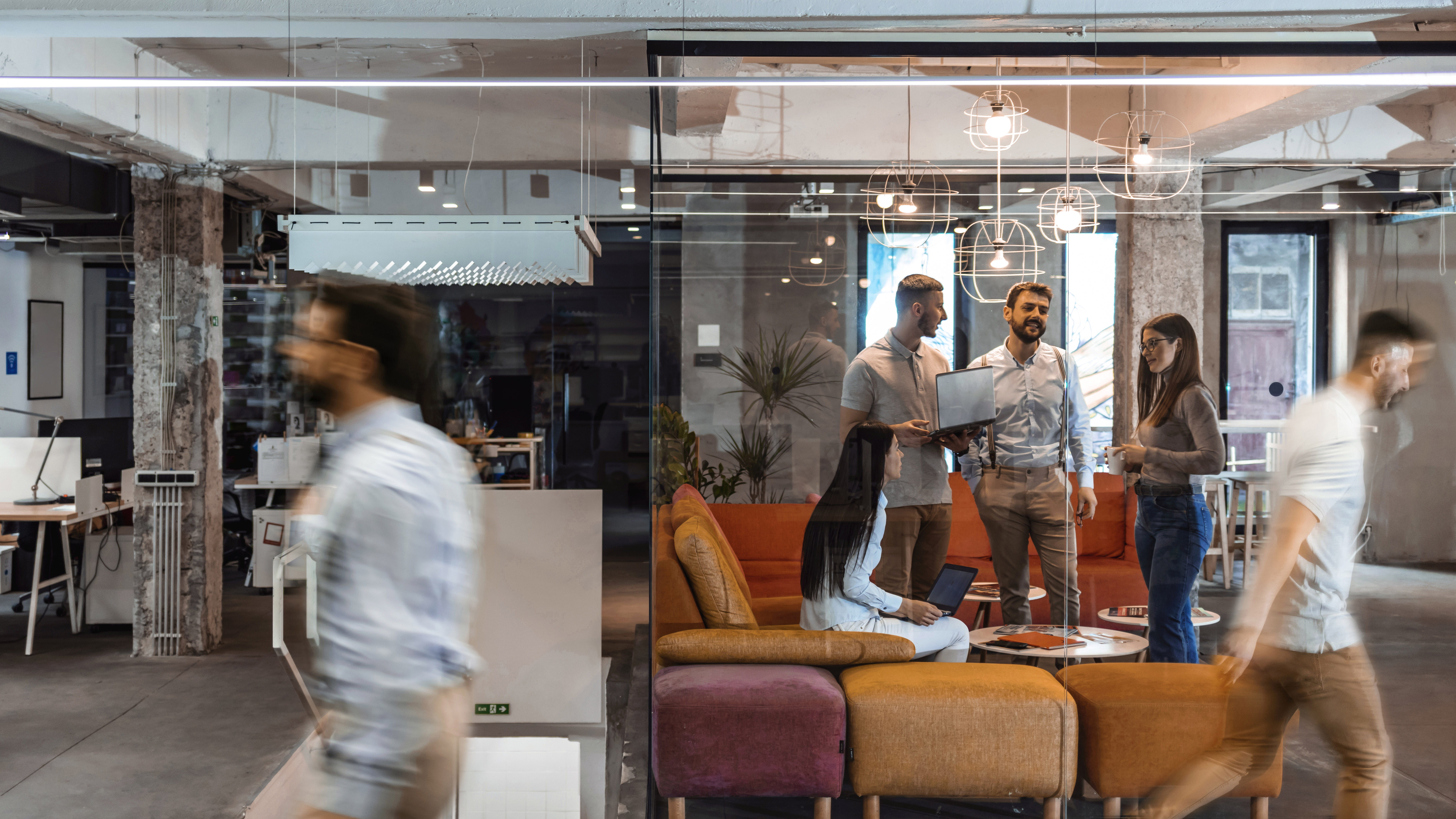 公司员工一起工作的员工使用电脑进行联合办公，忙碌的员工群坐在办公桌前运动行走，在现代开放空间的房间内部，日常办公匆忙的生活方式概念。