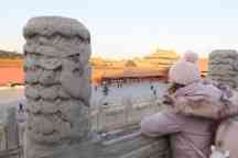 在中国北京，一位身着粉色服装的女子正望着一座寺庙