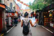 独自旅行的年轻女子在新加坡街头市场查看地图