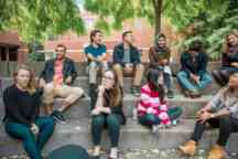学生大使们坐在校园外的台阶上进行社交活动