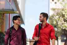 两个穿着红色衣服的男学生走到外面聊天