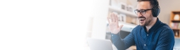 Male student studying online waving at webcam