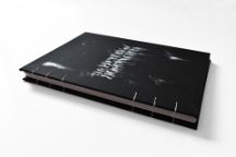这是一本开封的黑色精装书，标题是《多里安·格雷的照片》，字母看起来就像用白色粉末涂抹而成