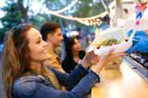 群有吸引力的年轻朋友选择和购买不同类型的快餐在街上吃市场上。