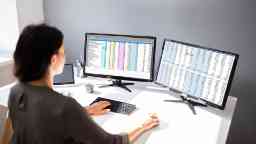女商人在一个工作站计算机数据分析在双显示器。