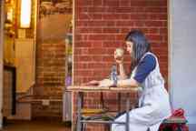 年轻女学生坐在一桌喝咖啡和阅读